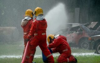 Three firefighters help and support to use fire sprinkler to spray water mix with special foam