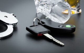 Car key on the bar with spilled alcohol