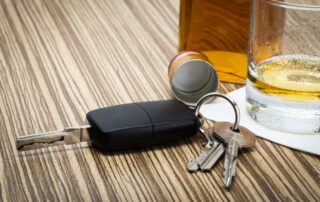 Car key on the bar with spilled alcohol