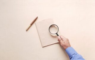 hand in magnifying glass inspecting 404 error.