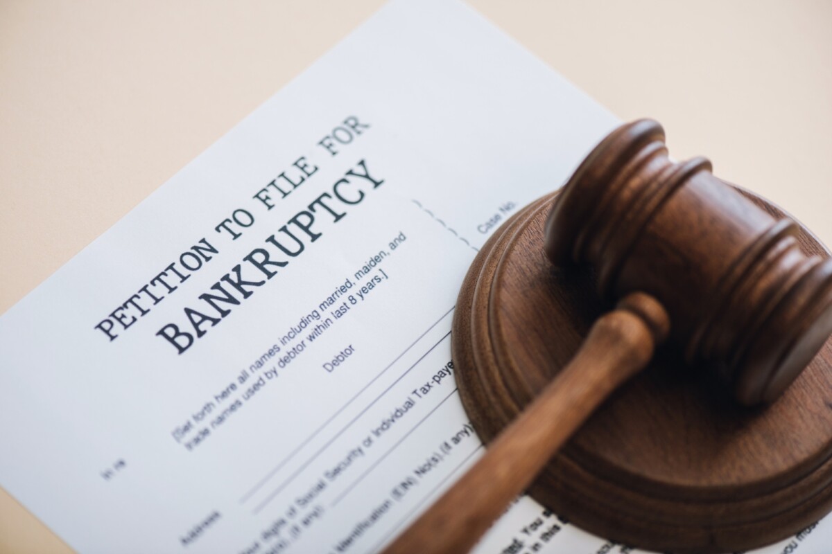 High angle view of gavel on document with petition to file for bankruptcy lettering isolated on