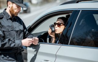 Policeman checking woman driver for alcohol intoxication