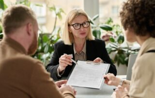 Woman handing contract to couple