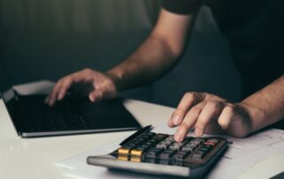 Asian man is using a calculator to calculate his family's monthly miscellaneous expenses