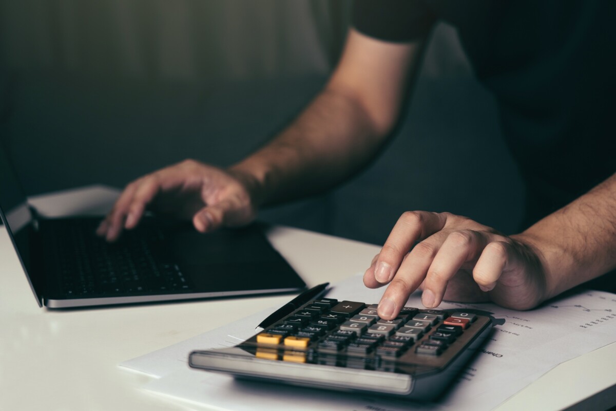 Asian man is using a calculator to calculate his family's monthly miscellaneous expenses