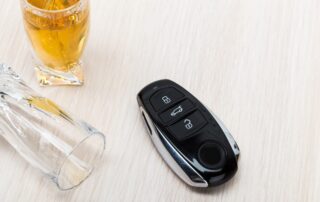 Car key on the bar with spilled alcohol