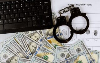 Cyber financial crime with handcuffs on money US hundred dollar bills to fingerprinting crime page