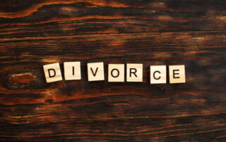 inscription divorce made by wooden blocks on wooden background. broken family concept.