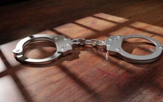 Jail bar shadow and handcuff on a wooden table. Prison, conviction and incarceration. 3d render