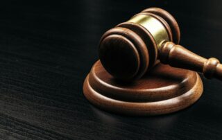 Judge's gavel on wooden table in dark