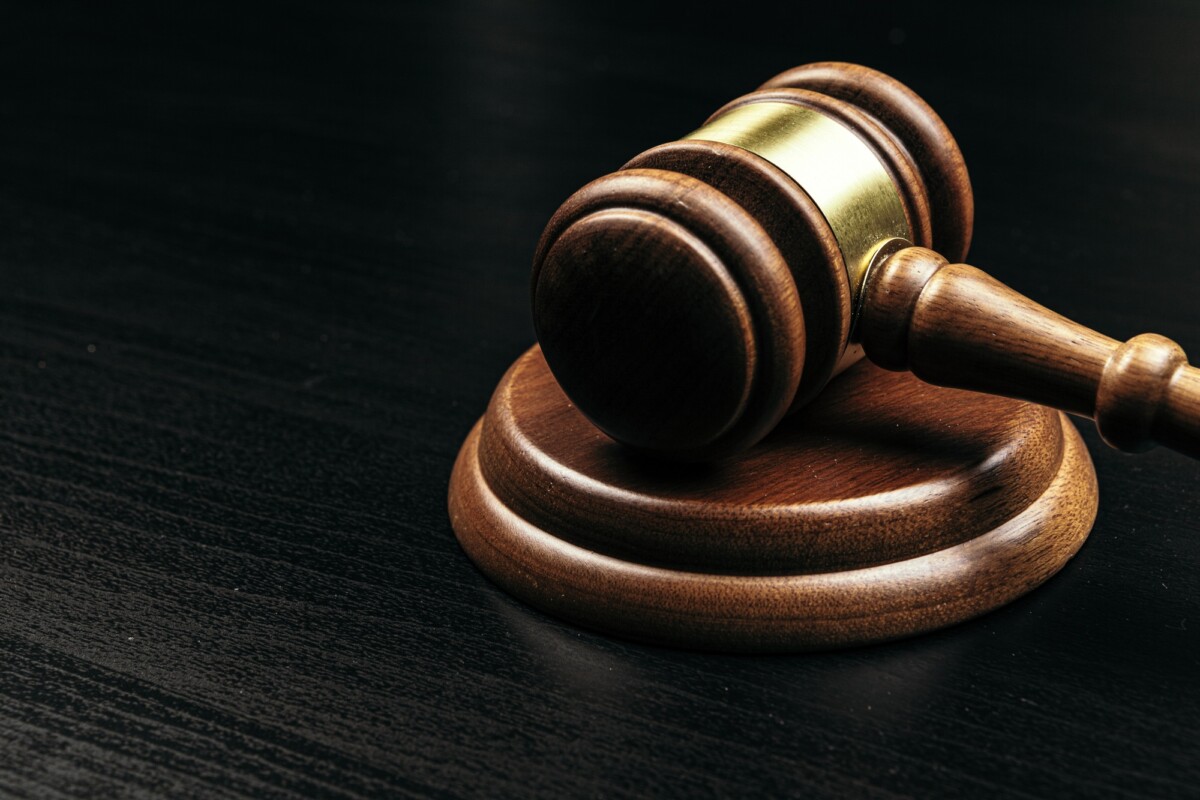 Judge's gavel on wooden table in dark
