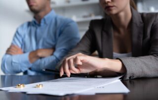 partial view of couple at table with divorce documents