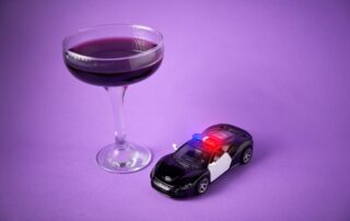 Toy police car with a wine glass. Drunk driving concept and breathalyzer